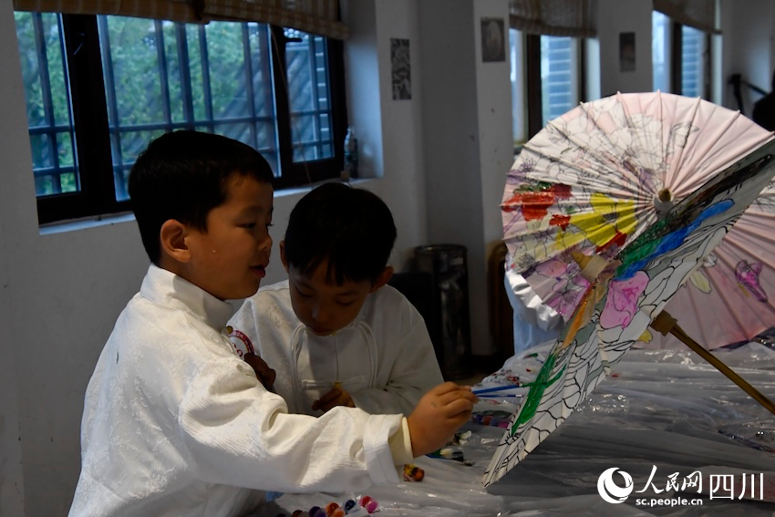 油纸伞博物馆,孩子们沉浸在油纸伞绘制的快乐中。人民网记者 郭莹摄 油纸伞博物馆,孩子们沉浸在油纸伞绘制的快乐中。人民网记者 郭莹摄