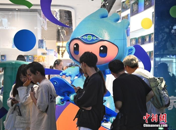 资料图：9月23日，杭州第19届亚运会开幕式在浙江杭州奥体中心体育场举行。图为游人在亚运特许商品店外排队购物。<a target='_blank' href='/'>中新社</a>记者 王刚 摄