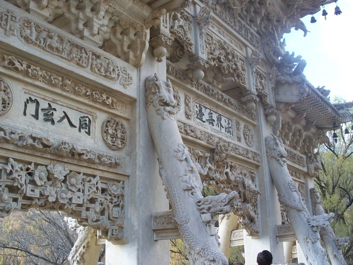 龙泉寺的石牌坊,四柱三门,上盖三个楼头,分上下两层,居中的楼头既高且