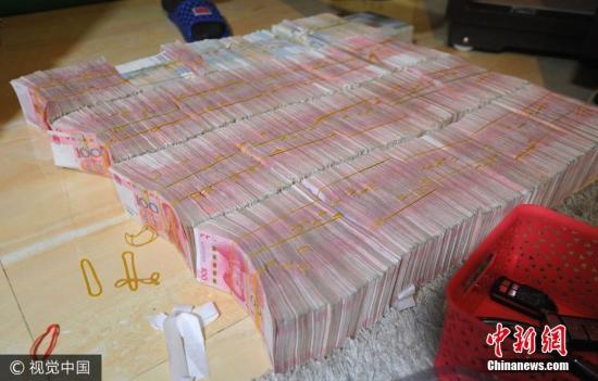 广西南宁警方8月21日通报，当地近日成功侦破涉案金额15.19亿元人民币的特大传销案件。图为当场缴获的成捆现金。图片来源：视觉中国