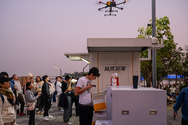 在深圳,外国游客体验无人机外卖送餐。