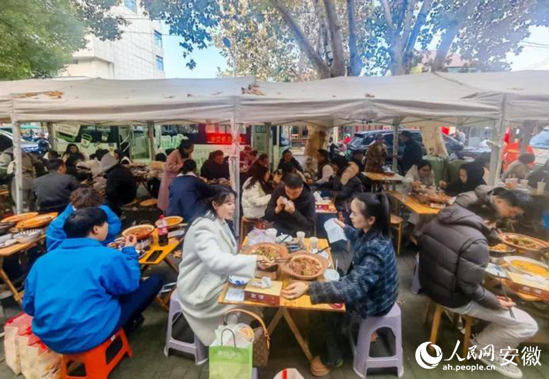 迎春街上，游客们品尝广德炖锅。人民网记者 王锐摄